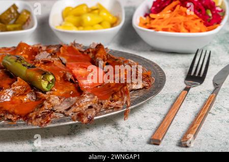 iskender Kebab. Traditionelle türkische Küche mit Tomatensauce und Butter. iskender Döner auf grauem Hintergrund Stockfoto