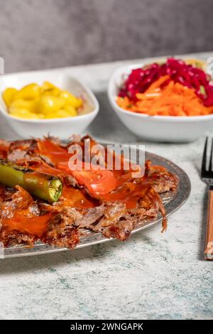 iskender Kebab. Traditionelle türkische Küche mit Tomatensauce und Butter. iskender Döner auf grauem Hintergrund Stockfoto