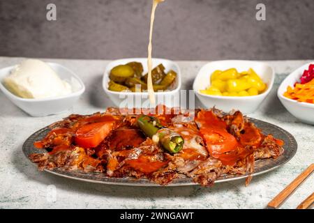 iskender Kebab. Traditionelle türkische Küche mit Tomatensauce und Butter. iskender Döner auf grauem Hintergrund Stockfoto