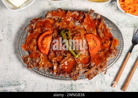 iskender Kebab. Traditionelle türkische Küche mit Tomatensauce und Butter. iskender Döner auf grauem Hintergrund Stockfoto