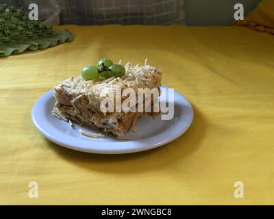 Köstlicher, kalter Hühnerkuchen mit Kartoffelpüree und Trauben auf einem rustikalen Holzbrett Stockfoto