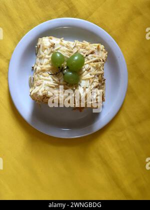 Köstlicher, kalter Hühnerkuchen mit Kartoffelpüree und Trauben auf einem rustikalen Holzbrett Stockfoto