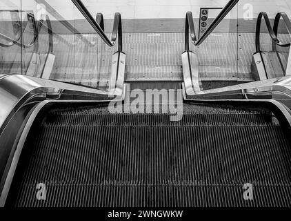 Aufsteigende Ambitionen... Elektrische Treppen im Einkaufszentrum. Schwarz-weiß. Schwarzweiß. Stockfoto