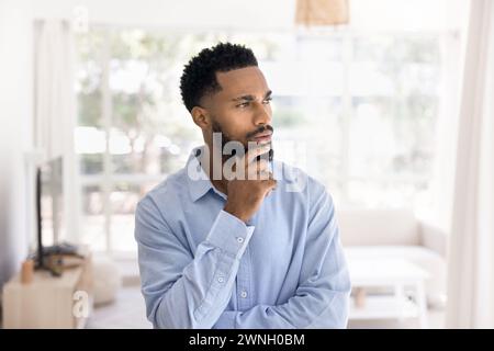 Ernsthaftes nachdenkliches attraktives junger afrikanischer Mann Innenporträt Stockfoto