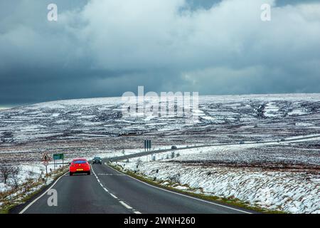 Red cr fährt auf der A537 Macclesfield nach Buxton Road durch das schneebedeckte Axe Edge Moor am Cheshire Derbyshire Border Peak District Stockfoto