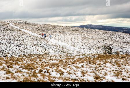 Eine Gruppe von Menschen stürzte über ein schneebedecktes Axe Moor im English Peak District England UK Stockfoto