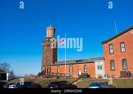 Die US-Flagge winkt im Wind neben dem Nordturm der historischen Navesink Twin Lighthouses in Highlands, New Jersey, USA -18 Stockfoto