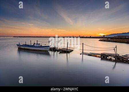 Winter Sonnenuntergang in einigen kleinen Booten in der Bucht von Badia dels Alfacs, im Ebro-Delta (Tarragona, Katalonien, Spanien) ESP: Atardecer de invierno al Delta Stockfoto