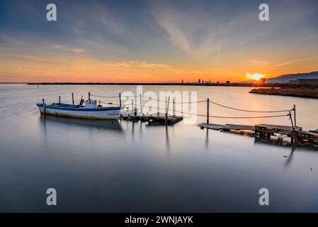 Winter Sonnenuntergang in einigen kleinen Booten in der Bucht von Badia dels Alfacs, im Ebro-Delta (Tarragona, Katalonien, Spanien) ESP: Atardecer de invierno al Delta Stockfoto