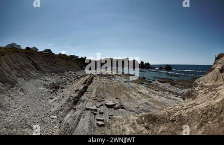 Gebrochene Küste in Liencres Cantabria, an einem sonnigen Sommertag bei Ebbe. Leerer Strand, Ebbe, klarer Himmel, Luftaufnahme Stockfoto