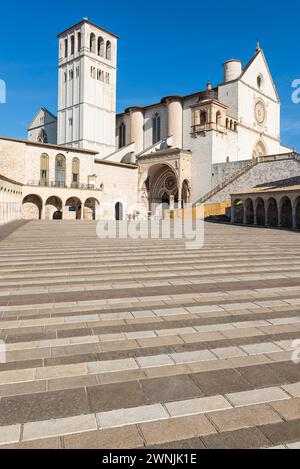 Kolonnaden umgeben den unteren Platz vor der Basilika des hl. Franziskus von Assisi in der Morgensonne in Umbrien, Italien Stockfoto