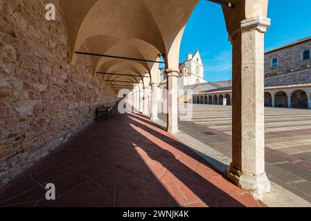 Blick durch Säulen auf die Basilika des hl. Franziskus von Assisi in der Morgensonne, Umbrien, Italien Stockfoto