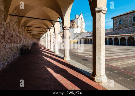 Blick durch Säulen auf die Basilika des hl. Franziskus von Assisi in der Morgensonne, Umbrien, Italien Stockfoto