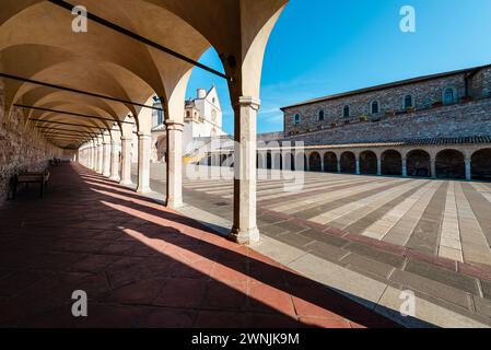 Blick durch Säulen auf die Basilika des hl. Franziskus von Assisi in der Morgensonne, Umbrien, Italien Stockfoto