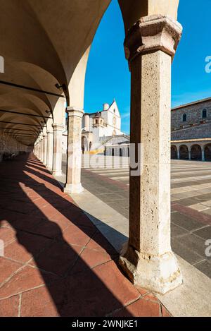 Blick durch Säulen auf die Basilika des hl. Franziskus von Assisi in der Morgensonne, Umbrien, Italien Stockfoto