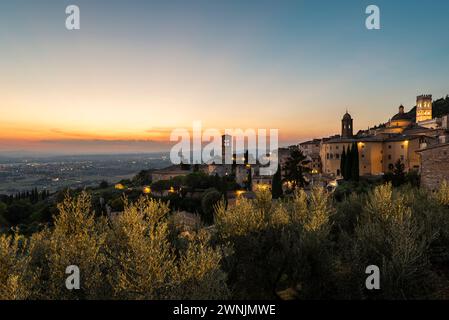 Blick vom Piazza Santa Chiara auf den goldenen Sonnenuntergang über das Umbra-Tal und die Altstadt von Assisi, Umbrien, Italien Stockfoto