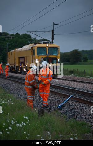 Schottermaschine mit Eisenbahnunternehmen für Network Rail Verpacken von Ballast unter neuer Gleise bei Brock, nördlich von Preston an der Westküste Stockfoto