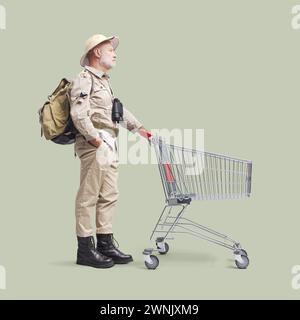 Ein älterer Abenteurer, der Lebensmittel einkauft, schiebt einen leeren Einkaufswagen Stockfoto