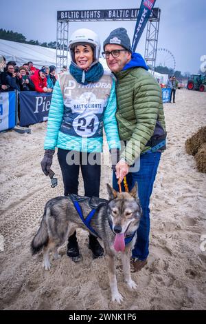 Heringsdorf, Deutschland. März 2024. Schauspielerin Gerit Kling und ihr Mann Wolfram Becker beim „Baltic Lights“-Schlittenhund-Rennen. Um Spenden für die Welthungerhilfe zu sammeln, treten Profis und Prominente in Teams mit 500 Huskys am Strand gegeneinander an. Rund 60.000 Zuschauer werden am Wochenende an der mehrtägigen Wohltätigkeitsveranstaltung teilnehmen. Quelle: Jens Büttner/dpa/Alamy Live News Stockfoto