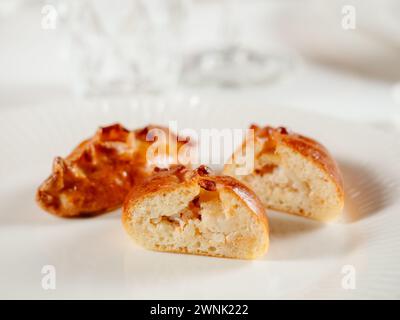 Kleine russische Torten mit gehacktem Lachsfisch russischer Piroschki. Gekochter Thunfisch handportionierte Torten oder Empanadas, halbiert auf weißer Platte in eleganter Form Stockfoto