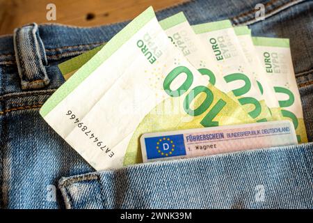 Hundert-Euro-Scheine und EU-Führerschein in Jeans-Tasche 03.03.24, Limburg: Symbolfoto, Illustrationsbild, Symbolbild, Illustrationsfoto Hundert-Euro-Scheine und EU-Führerschein in Jeans-Tasche das Bild präsentiert eine detailreiche Aufnahme, in der mehrere Hundert-Euro-Scheine zusammen mit einem EU-Führerschein in der Gesäßtasche einer blauen Jeans steckt. Die Jeans und der Führerschein sind nur im Anschnitt zu erkennen, wodurch das Augenmerk auf die Wertgegenstände in der Tasche gerichtet wird. Limburg Hessen Deutschland *** Hundert Euro-Scheine und EU-Führerschein in Jeanstasche 03 03 24, Li Stockfoto