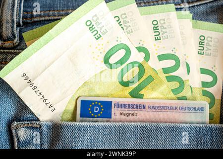 Hundert-Euro-Scheine und EU-Führerschein in Jeans-Tasche 03.03.24, Limburg: Symbolfoto, Illustrationsbild, Symbolbild, Illustrationsfoto Hundert-Euro-Scheine und EU-Führerschein in Jeans-Tasche das Bild präsentiert eine detailreiche Aufnahme, in der mehrere Hundert-Euro-Scheine zusammen mit einem EU-Führerschein in der Gesäßtasche einer blauen Jeans steckt. Die Jeans und der Führerschein sind nur im Anschnitt zu erkennen, wodurch das Augenmerk auf die Wertgegenstände in der Tasche gerichtet wird. Limburg Hessen Deutschland *** Hundert Euro-Scheine und EU-Führerschein in Jeanstasche 03 03 24, Li Stockfoto