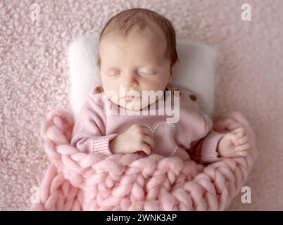 Baby Girl In Pink Outfit Schläft Während Der Neugeborenen-Fotosession Im Studio Stockfoto