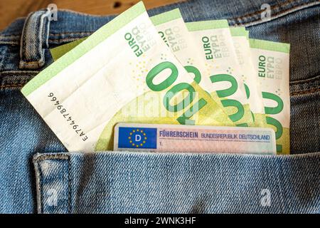 Hundert-Euro-Scheine und EU-Führerschein in Jeans-Tasche 03.03.24, Limburg: Symbolfoto, Illustrationsbild, Symbolbild, Illustrationsfoto Hundert-Euro-Scheine und EU-Führerschein in Jeans-Tasche das Bild präsentiert eine detailreiche Aufnahme, in der mehrere Hundert-Euro-Scheine zusammen mit einem EU-Führerschein in der Gesäßtasche einer blauen Jeans steckt. Die Jeans und der Führerschein sind nur im Anschnitt zu erkennen, wodurch das Augenmerk auf die Wertgegenstände in der Tasche gerichtet wird. Limburg Hessen Deutschland *** Hundert Euro-Scheine und EU-Führerschein in Jeanstasche 03 03 24, Li Stockfoto