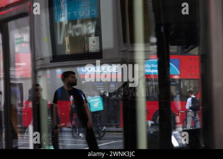 Fußgänger und Radfahrer werden während der Hauptverkehrszeit durch die Fenster eines Busses gesehen. Borough High Street, London, Großbritannien. Juli 2023 Stockfoto