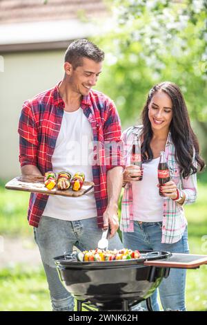 März. 02. 2024 Liptovsky Mikulas. Slowakei - Freundinnen und Freundinnen teilen sich im Sommer Grillparty mit gegrilltem Fleisch und Gemüse und Flaschen Coca Stockfoto