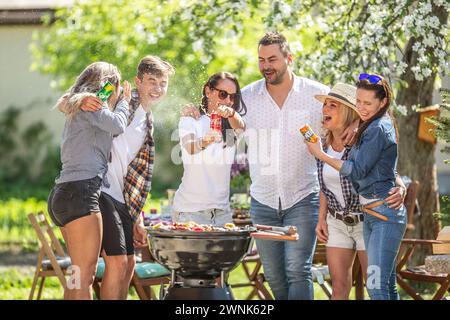 März. 02. 2024 Liptovsky Mikulas. Slowakei - eine Gruppe von Freunden macht Spaß während der Sommerfeier mit Grillgartenparty, während eine Frau eine Sprühdose öffnet Stockfoto