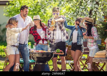 März. 02. 2024 Liptovsky Mikulas. Slowakei - Ein Teenager knallt einen Fanta, der beim Sommergarten und der grillparty alles über die Leute streut. Stockfoto