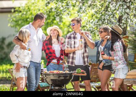 März. 02. 2024 Liptovsky Mikulas. Slowakei - eine Gruppe von Freunden macht Spaß bei der Gartenparty, plaudert, lacht, isst und trinkt Coca Cola an Stockfoto