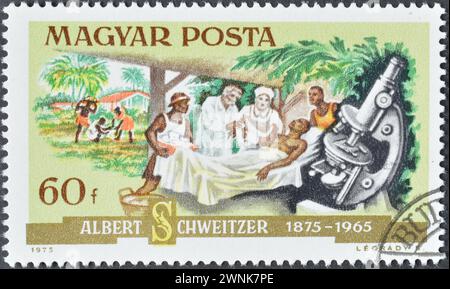 Gestempelte Briefmarke von Ungarn, die Dr. Schweitzer und einen Patienten zeigt, Hundertjahrfeier von Dr. Albert Schweitzer (1875-1965), um 1975 Stockfoto