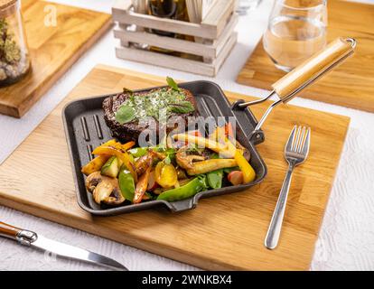 Gegrillte Schweinekoteletts mit geröstetem Gemüse auf Restauranttisch Stockfoto