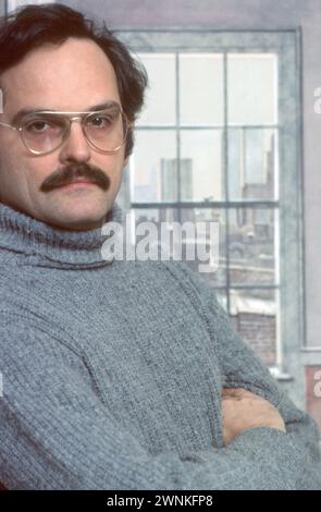 Der Trompe-L’Oiel-Künstler Richard Haas steht vor einer seiner Werke. 1977 in seinem Loft in Soho, New York City. Es ist eine bemalte Lobby zu einem zusätzlichen Zimmer mit Fensterblick, was man eigentlich sehen würde, wenn es dort wirklich ein Fenster gäbe. Stockfoto