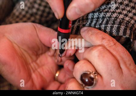 Ein Heidearbeiter markiert den Finger eines Kindes, nachdem er während einer landesweiten Pulse Polio-Immunisierung (PPI) in einem Gesundheitszentrum in einem abgelegenen Dorf in Budgam, nordöstlich von Srinagar, eine Dosis Polio-Impfstoff-Tropfen verabreicht hat. Mehr als 1,9 Millionen Kinder unter fünf Jahren erhalten am 3. März den Polio-Impfstoff in 11.000 Kabinen, in denen Impfstoffe über Hubschrauber in Jammu und Kaschmir in schneebetroffene Gebiete geschickt werden. Hochrangige Gesundheitsbeamte sagten den lokalen Medien, dass etwa 45.000 Beschäftigte im Gesundheitswesen in den Prozess einbezogen werden, um sicherzustellen, dass kein Kind zurückgelassen wird. Indien wurde eingeführt Stockfoto