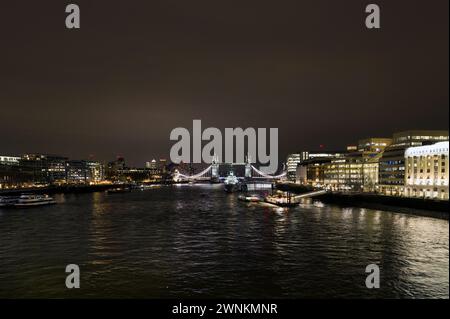 Kraftvolle abstrakte, architektonisch beleuchtete Nachtlandschaft der Themse, aufgenommen von der London Bridge und mit Tower Bridge, Canary Wharf, Tooley Street, London Bridge Hospital, HMS Belfast, London Bridge City Pier und Flussboote Stockfoto