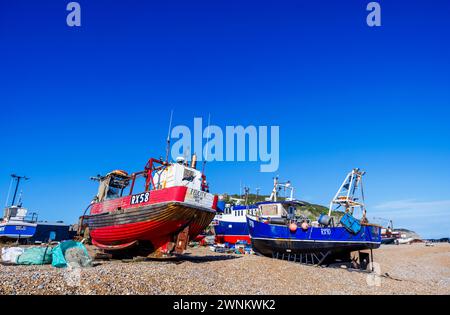 Buntes, traditionelles, hölzernes Fischerboot „Felicity“ und andere, die am Kieselstrand in Hastings, East Sussex, England, heraufgeholt wurden Stockfoto