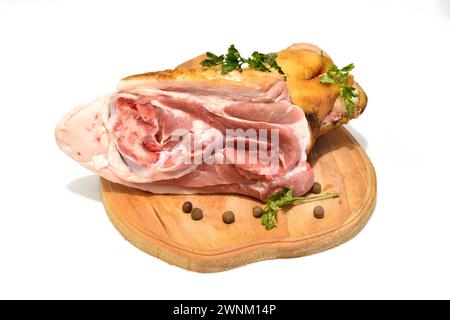 Frische Schweinshaxe liegt auf einem Schneidebrett auf weißem Hintergrund. Stockfoto