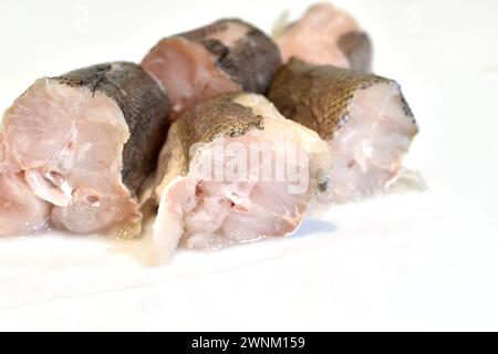 Mehrere Stücke frischen Seehechtfisches liegen auf dem Tisch. Stockfoto