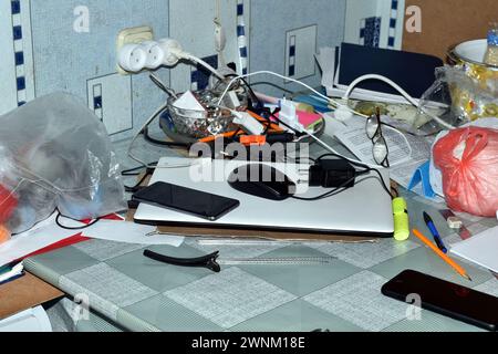 Das Bild zeigt einen Desktop im Büro, auf dem zahlreiche Dinge zurückblieben. Stockfoto