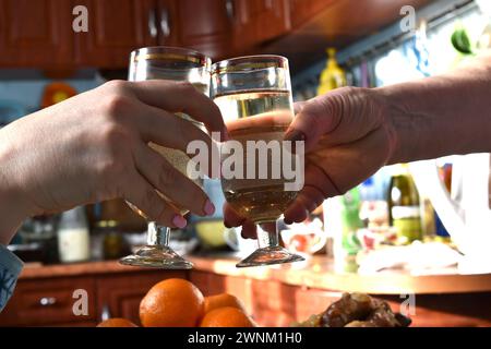 Weingläser in den Händen der feiernden Leute trafen auf klirrende Gläser über dem Tisch. Stockfoto