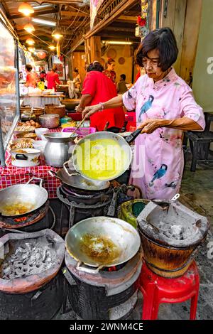 Thailand, 10. Februar 2024: Chakngeaw Chinese Village, Besucher kommen, um eine Vielzahl von Speisen zu sehen und zu probieren. Hier macht ein Verkäufer einen herzhaften Krepp. Stockfoto
