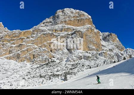 Skifahrer auf der Abfahrt von Col Pradat vor dem schneebedeckten Gipfel von Sassongher, Wintersportort Colfosco, Colfosco, Alta Badia Ski Stockfoto