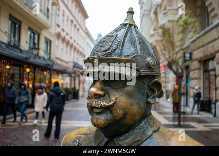 Der fette Polizist in Budapest, Ungarn, auch bekannt als Onkel Karl, hat ein wachsames Auge auf St. Stephans Basilika, während die Leute seinen Glücksbauch reiben. Stockfoto