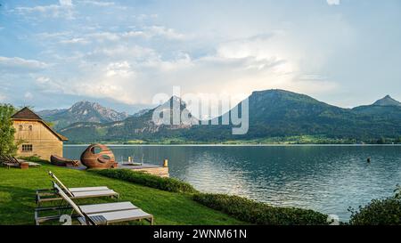 Eine ruhige Landschaft mit einem See vor majestätischen Bergen, einem Himmel mit hellen Wolken, Sankt Wolfgang, Wolfgangsee, Salzkammergut, Österreich Stockfoto