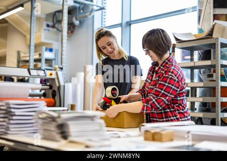 Weibliche Arbeiter Kleben Kartonschachteln Stockfoto