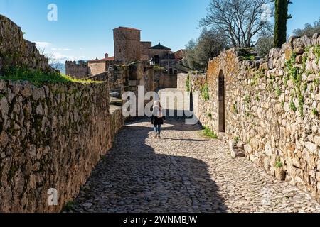 Weibliche Touristen schlendern durch die engen Gassen der mittelalterlichen Steinstadt Trujillo. Stockfoto