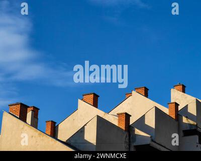 Oben aufsteigen. Bauen Sie Ziegelsteine auf dem Dach vor der riesigen blauen Skyline. Stockfoto